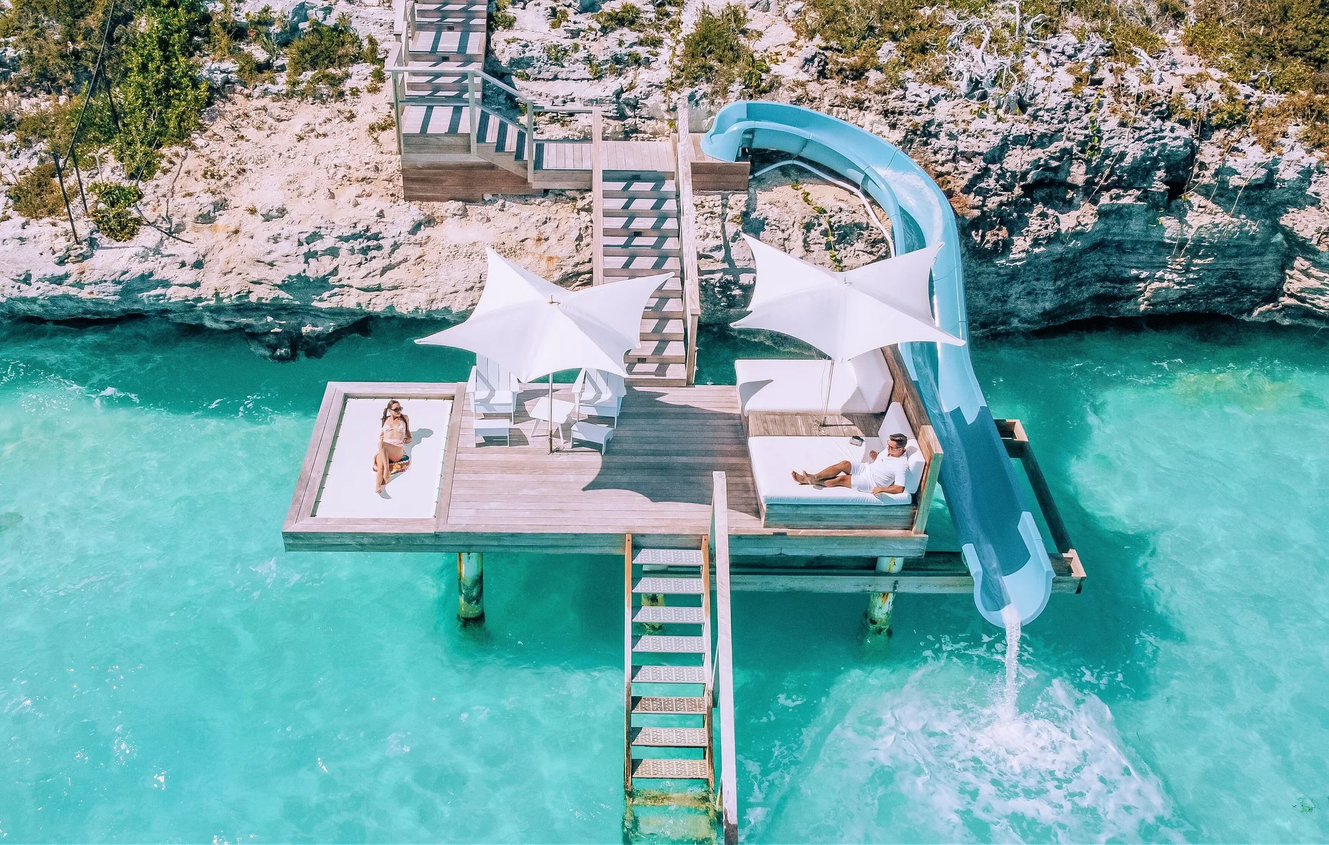 Private villa deck with water slide over turquoise sea at Wymara Resort and Villas.