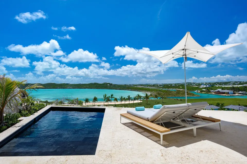 Villa terrace with plunge pool, loungers, umbrella and water views at Wymara Resort and Villas.
