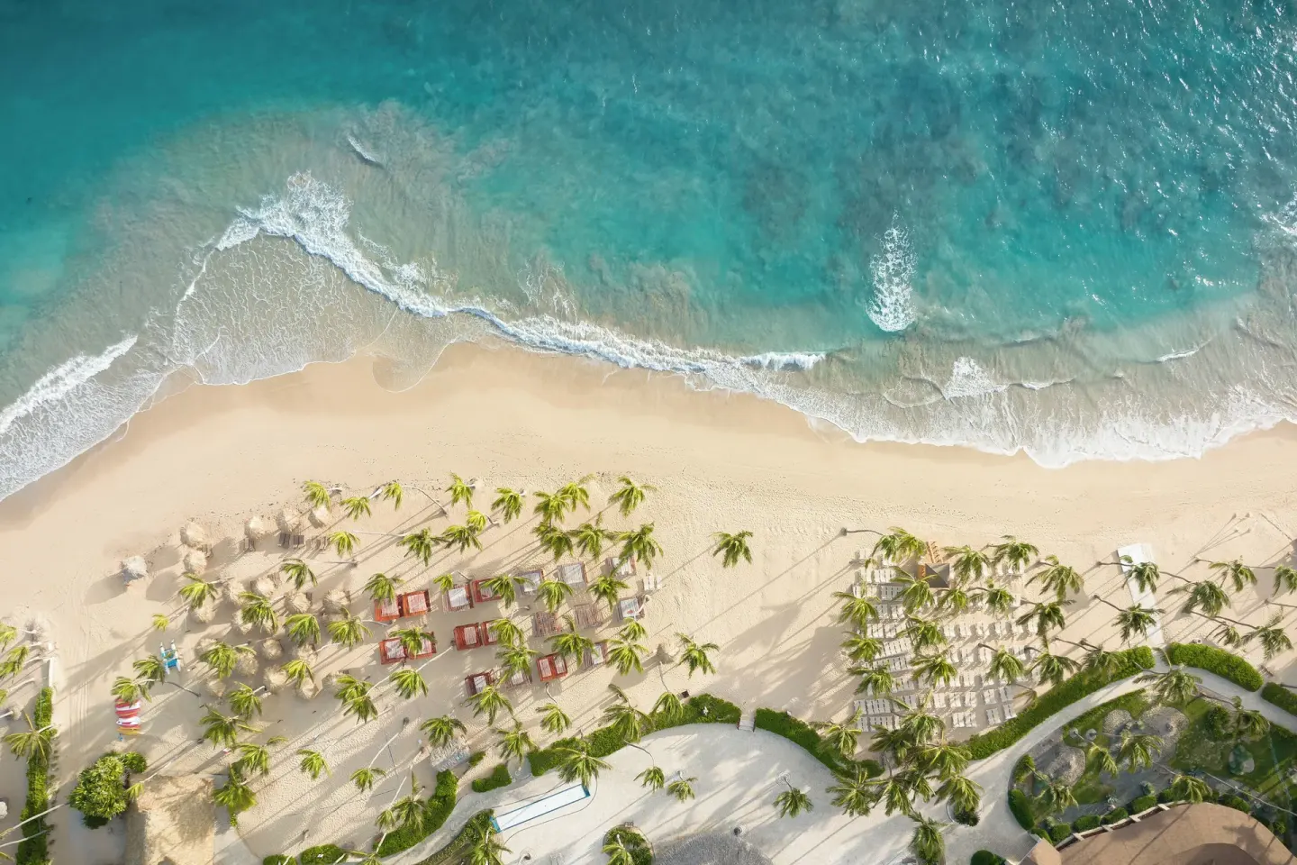 Aerial view of the beach and turquoise surf at Wyndham Alltra Punta Cana.