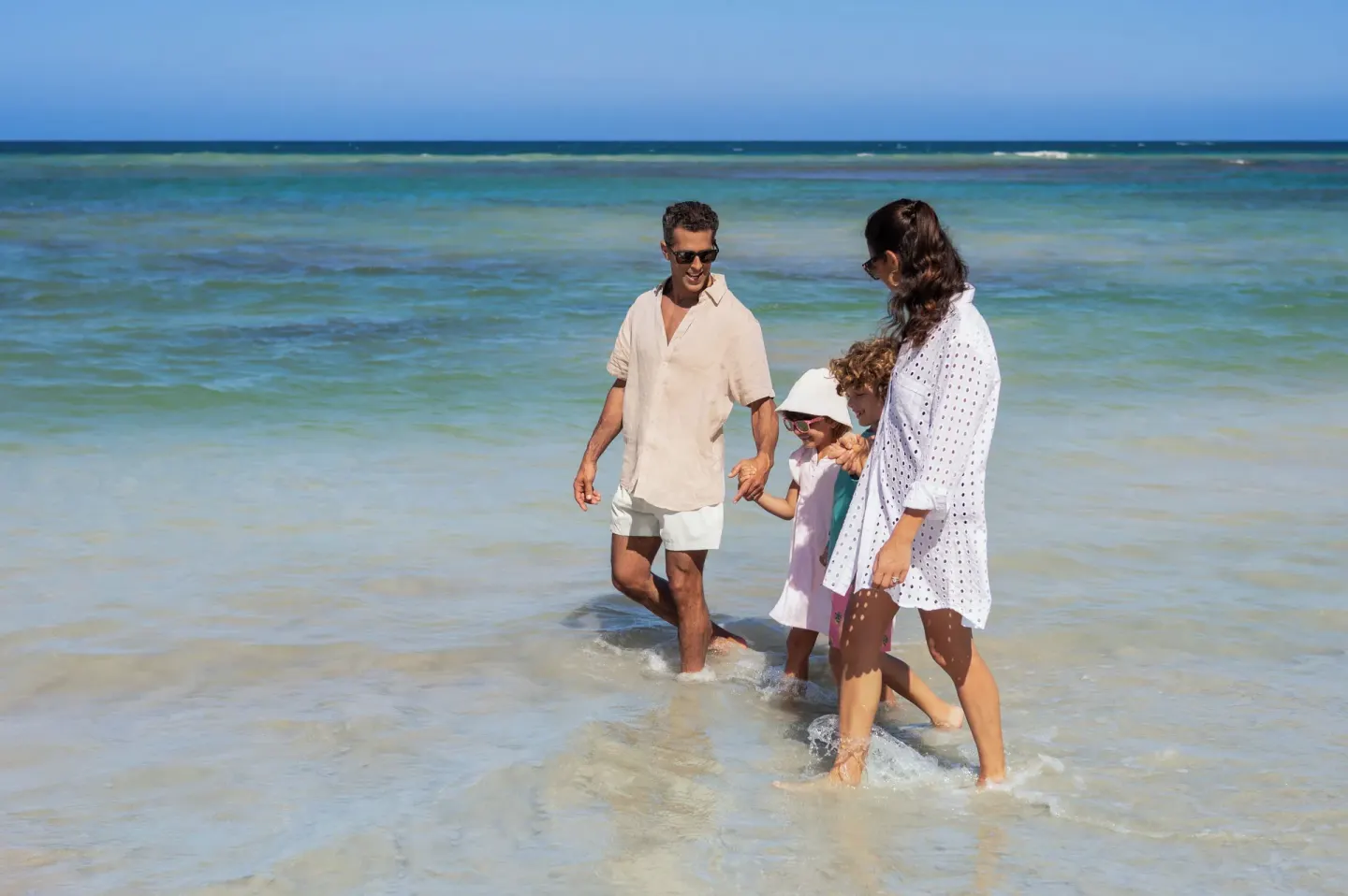 Family wading in shallow ocean water at Wyndham Alltra Punta Cana.