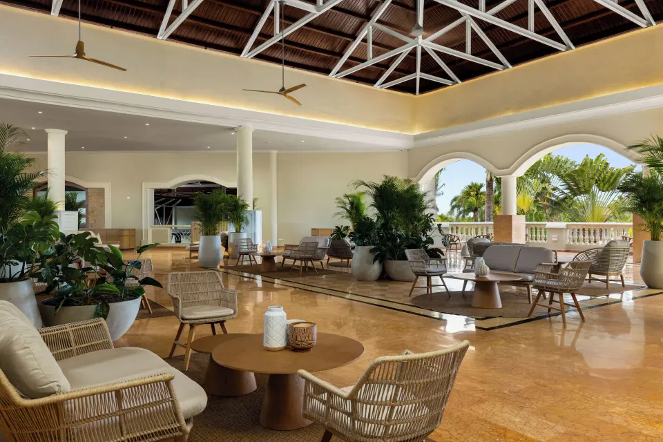 Open-air lobby lounge with woven seating and plants at Wyndham Alltra Punta Cana.