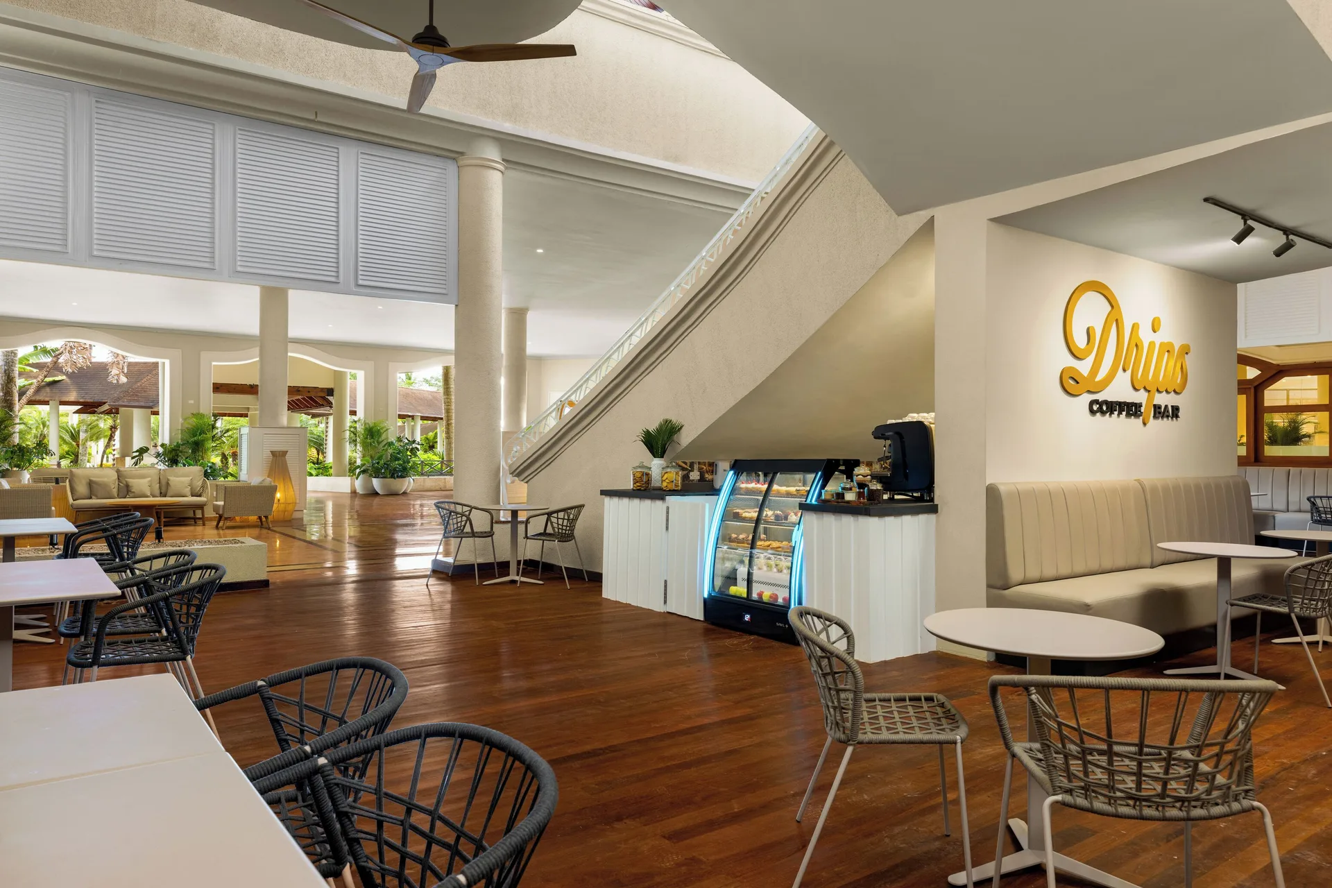 Drips coffee bar seating area under a staircase at Wyndham Alltra Punta Cana.