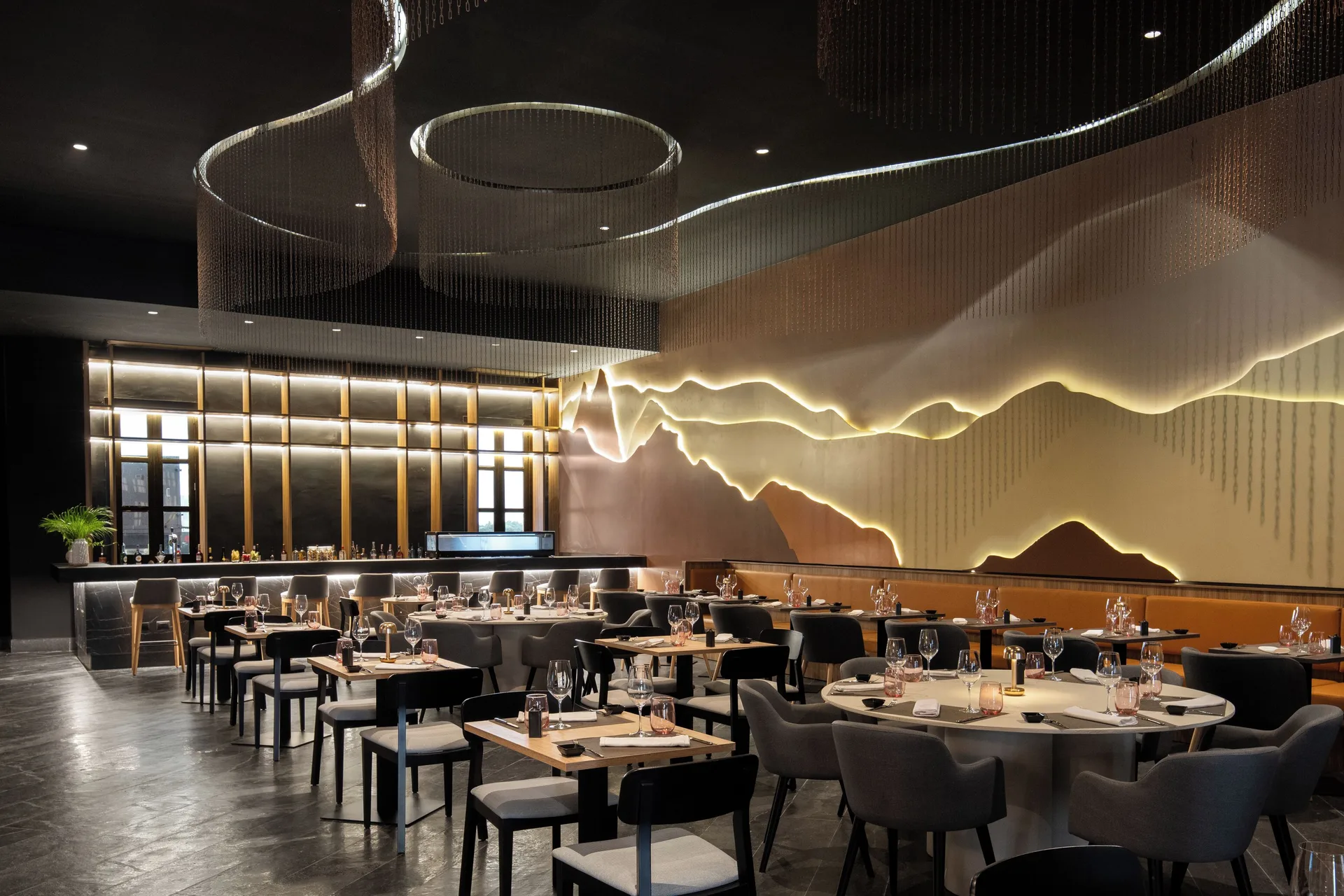 Modern restaurant dining room with illuminated wall art at Wyndham Alltra Punta Cana.