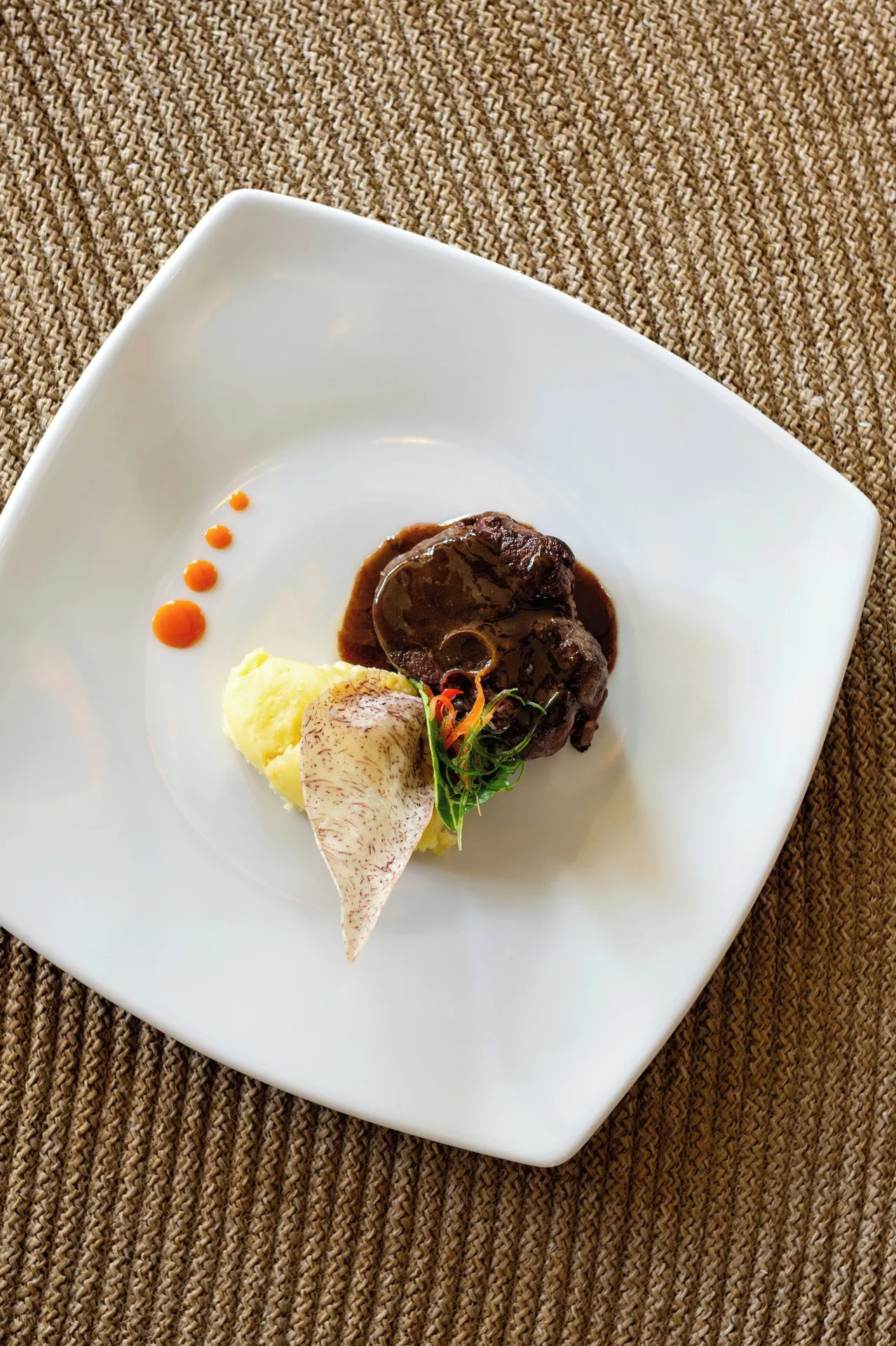 A plated meat dish with mashed potatoes and sauce at Wyndham Alltra Punta Cana.