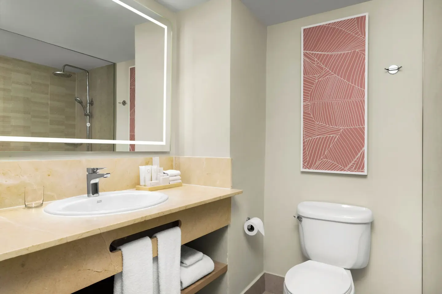 Standard room bathroom with vanity, mirror, toilet, and shower reflection at Wyndham Alltra Punta Cana.