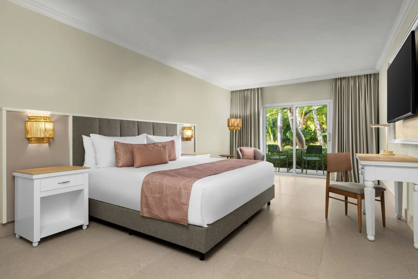 Standard tropical view king room with patio doors and garden greenery at Wyndham Alltra Punta Cana.