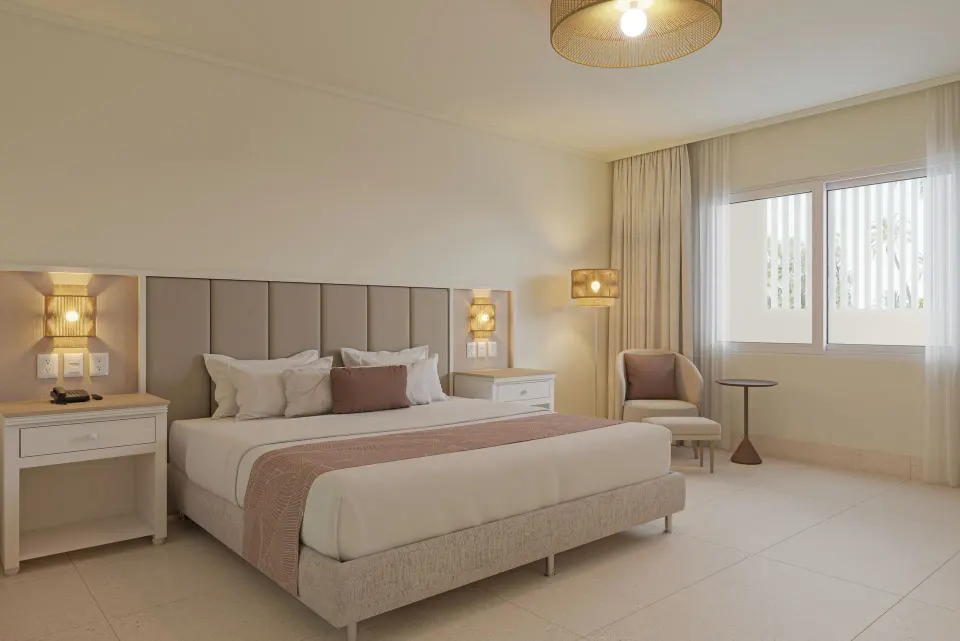 Standard tropical view room with a king bed and sitting corner at Wyndham Alltra Punta Cana.