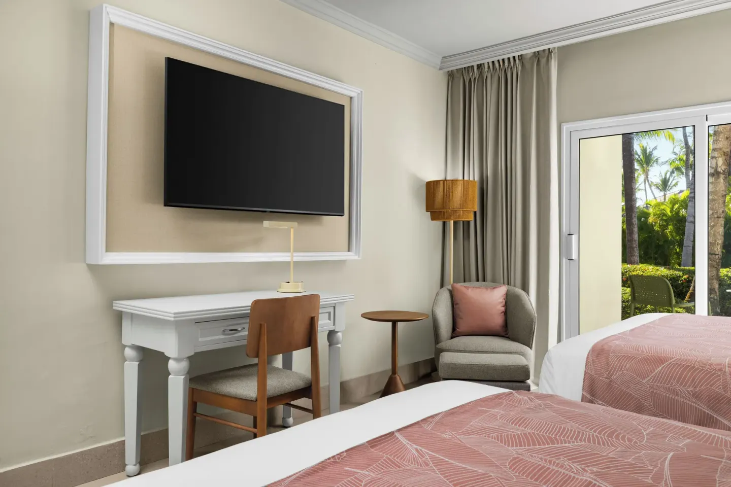 Standard tropical view room with two beds, desk, TV, and patio at Wyndham Alltra Punta Cana.
