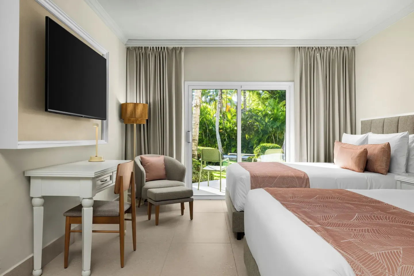 Standard tropical view room with two beds and garden-facing patio at Wyndham Alltra Punta Cana.