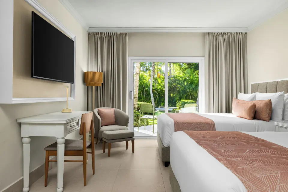 Standard tropical view room with two beds and garden-facing patio at Wyndham Alltra Punta Cana.