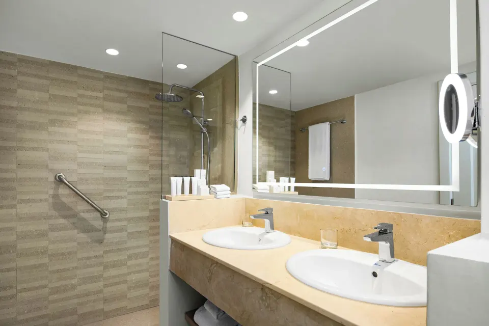 Suite bathroom with double sinks and glass shower at Wyndham Alltra Punta Cana.