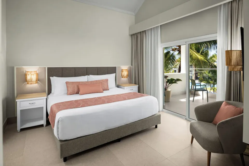 King bedroom with balcony and palm view at Wyndham Alltra Punta Cana.
