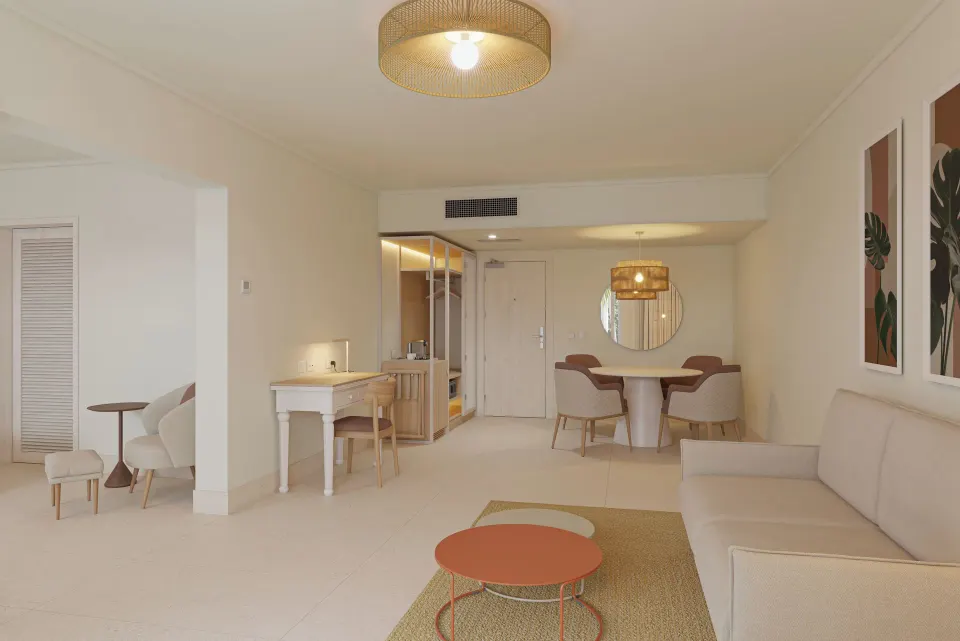 Suite living area with sofa, dining table, and vanity at Wyndham Alltra Punta Cana.
