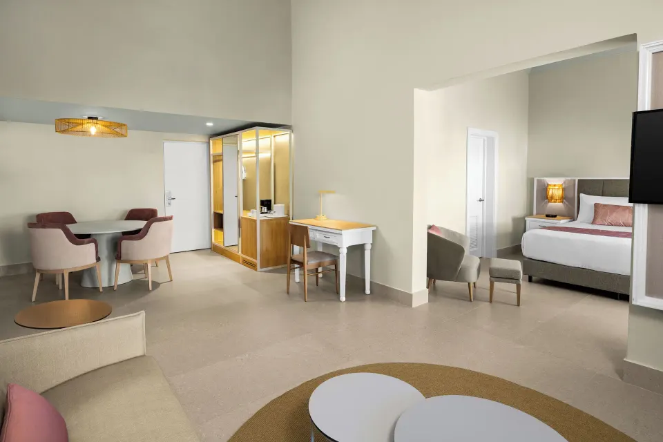 Two-bedroom suite living room with dining area and bedroom entry at Wyndham Alltra Punta Cana.
