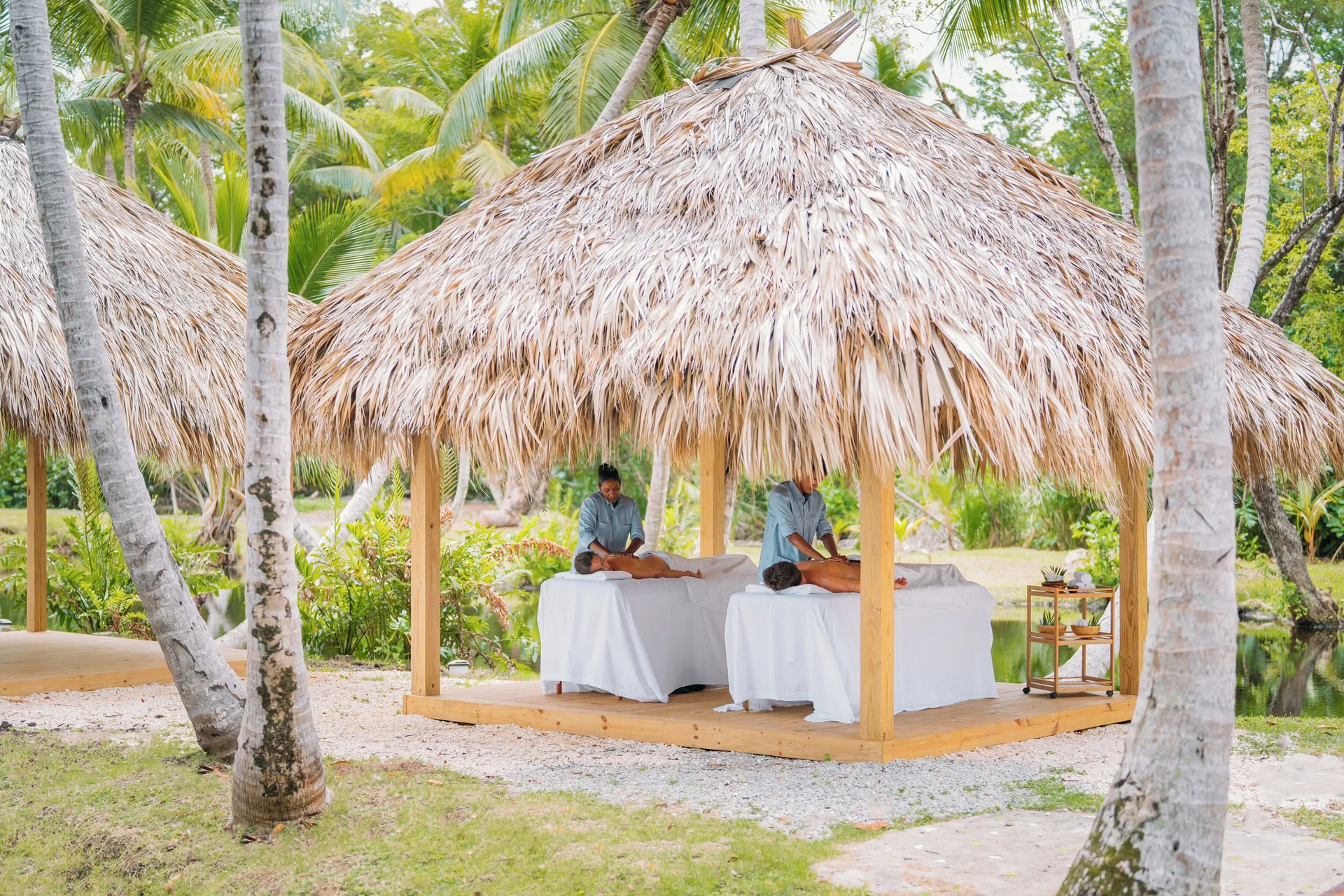 Couples massage setup in a thatched garden pavilion at Wyndham Alltra Samana Resort.