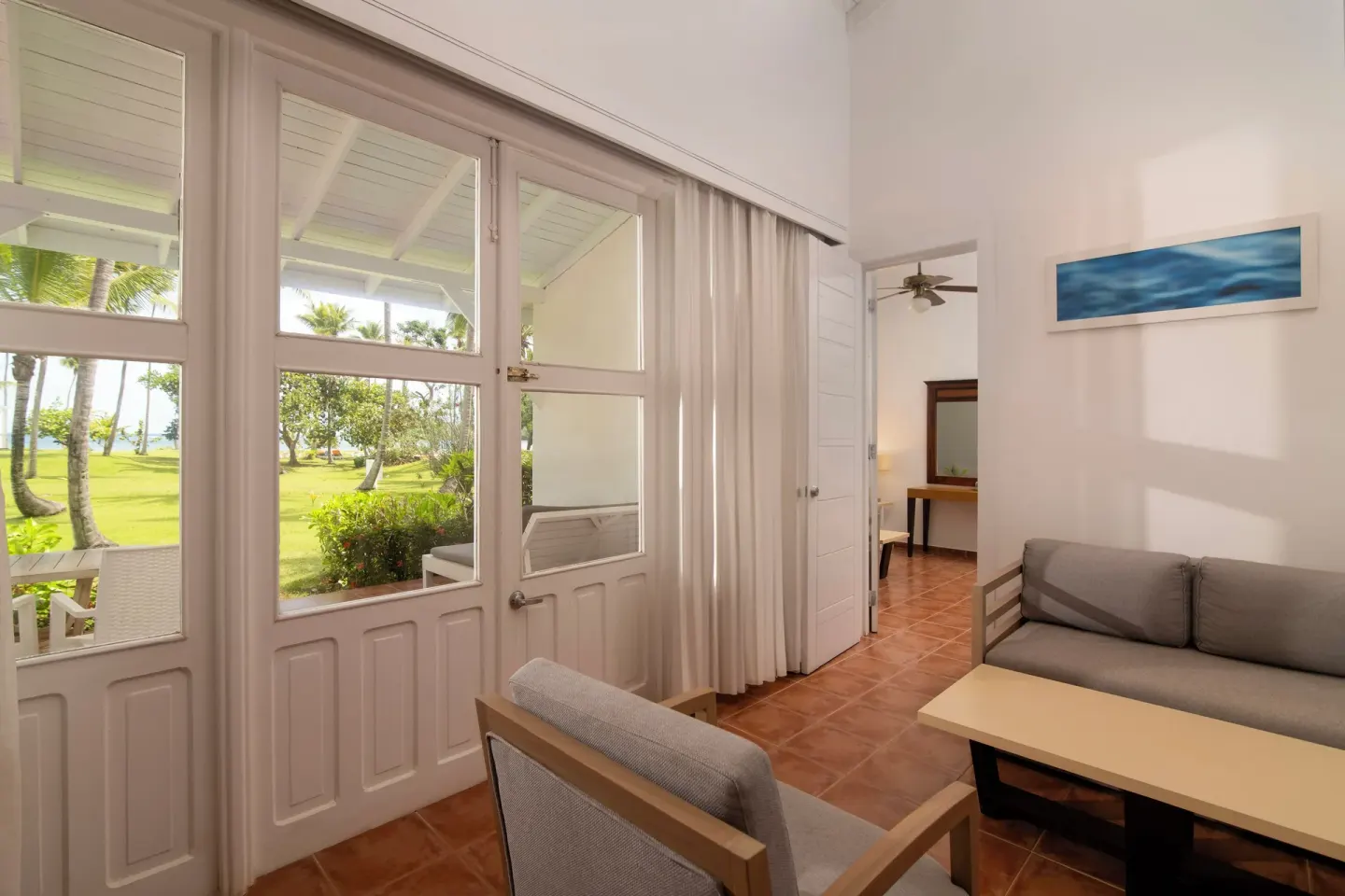 Guest room lounge area beside glass doors at Wyndham Alltra Samana Resort.