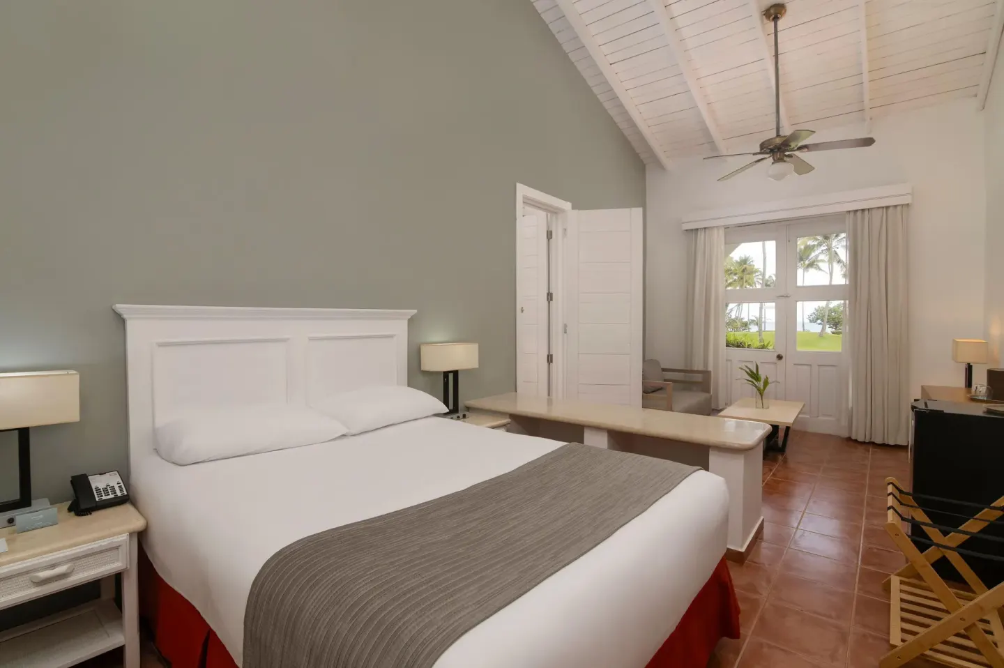 King guest room with terrace doors and palm views at Wyndham Alltra Samana Resort.