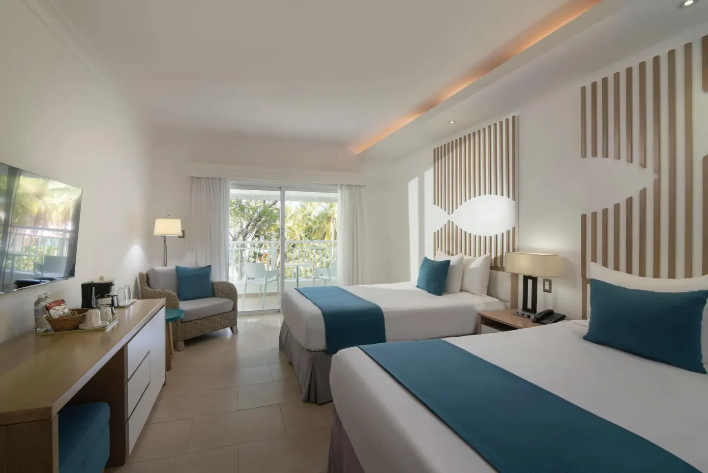 Two-bed guest room with blue accents and balcony at Wyndham Alltra Samana Resort.