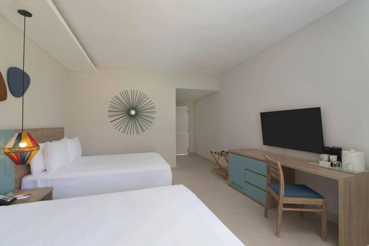Two-bed guest room with desk and wall-mounted TV at Wyndham Alltra Samana Resort.