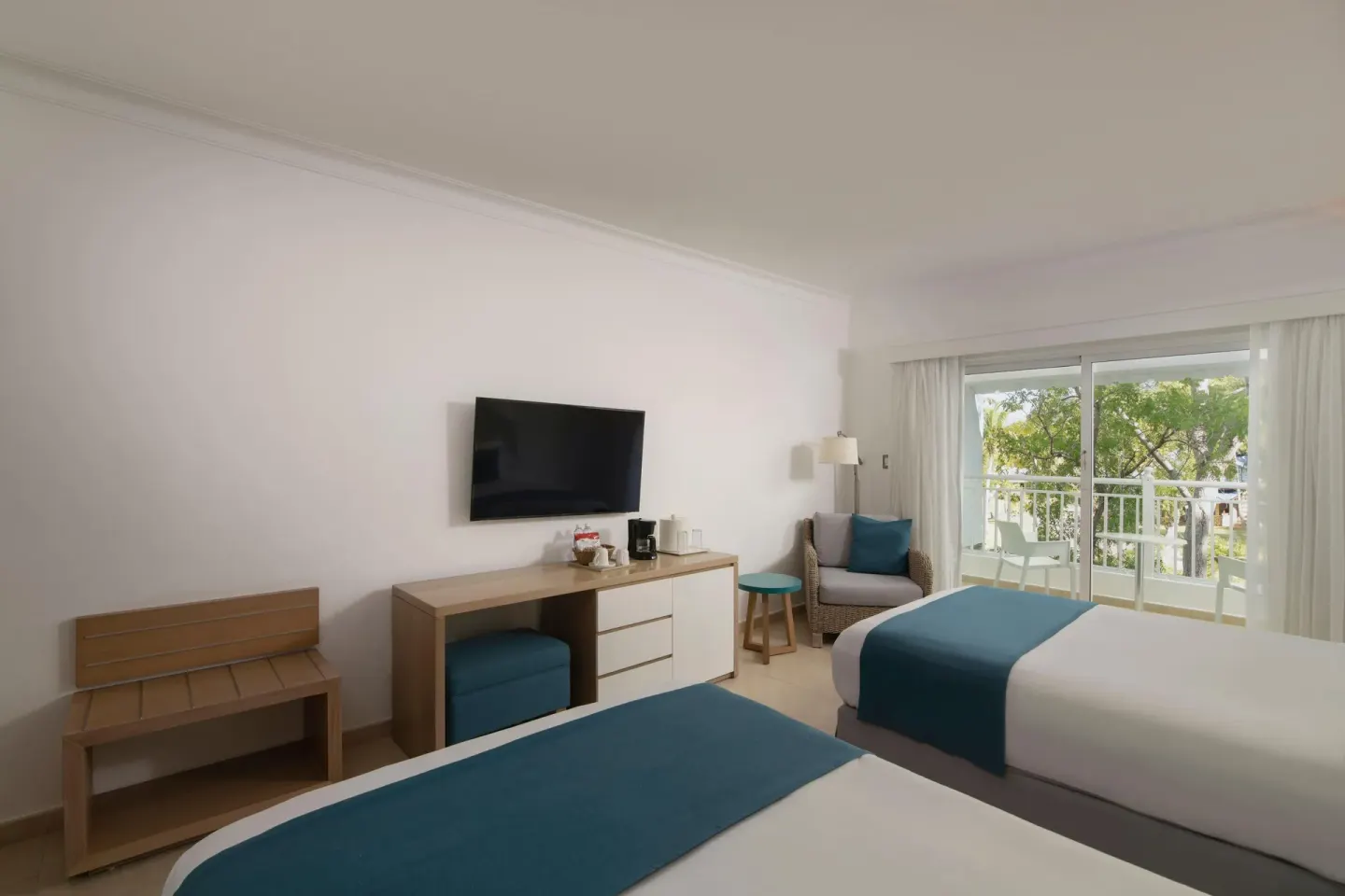 Two-bed guest room with media console and balcony at Wyndham Alltra Samana Resort.