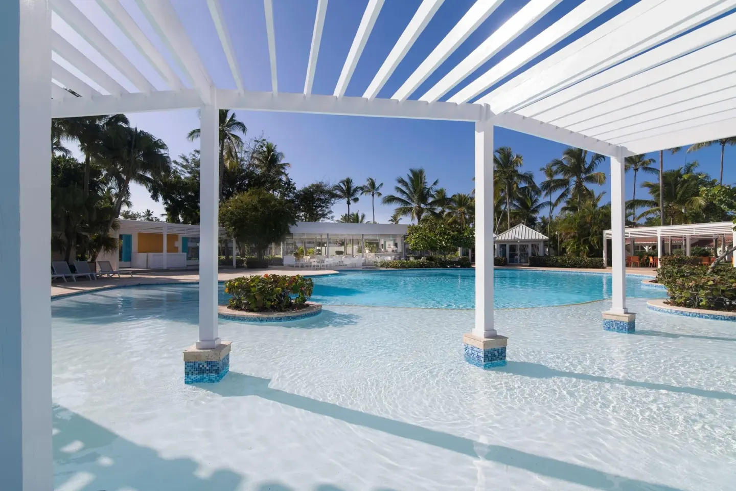 Shallow pool area under a white pergola at Wyndham Alltra Samana Resort.
