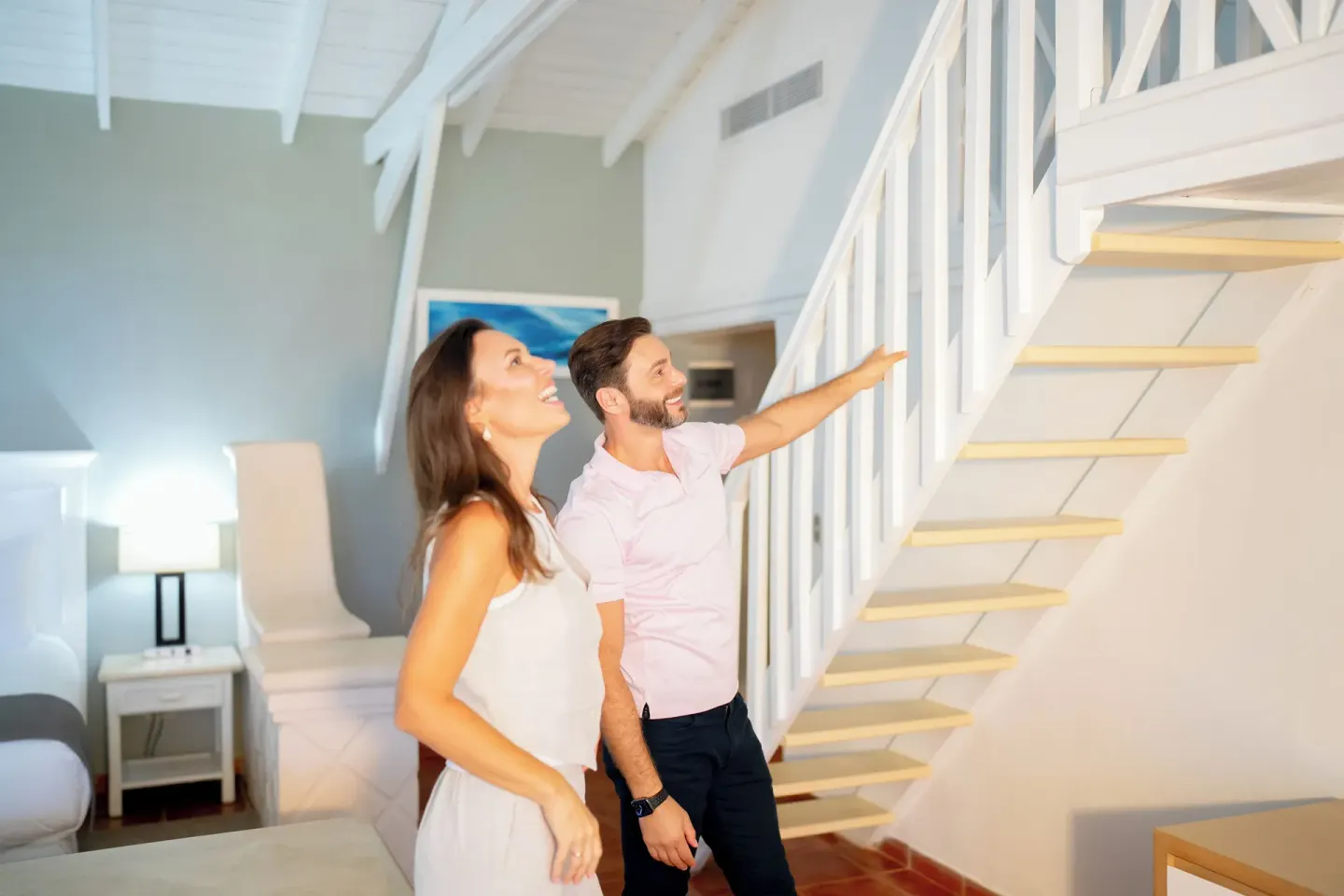 Guests stand by the loft stairs in a Club Bungalow Garden View room at Wyndham Alltra Samana Resort.