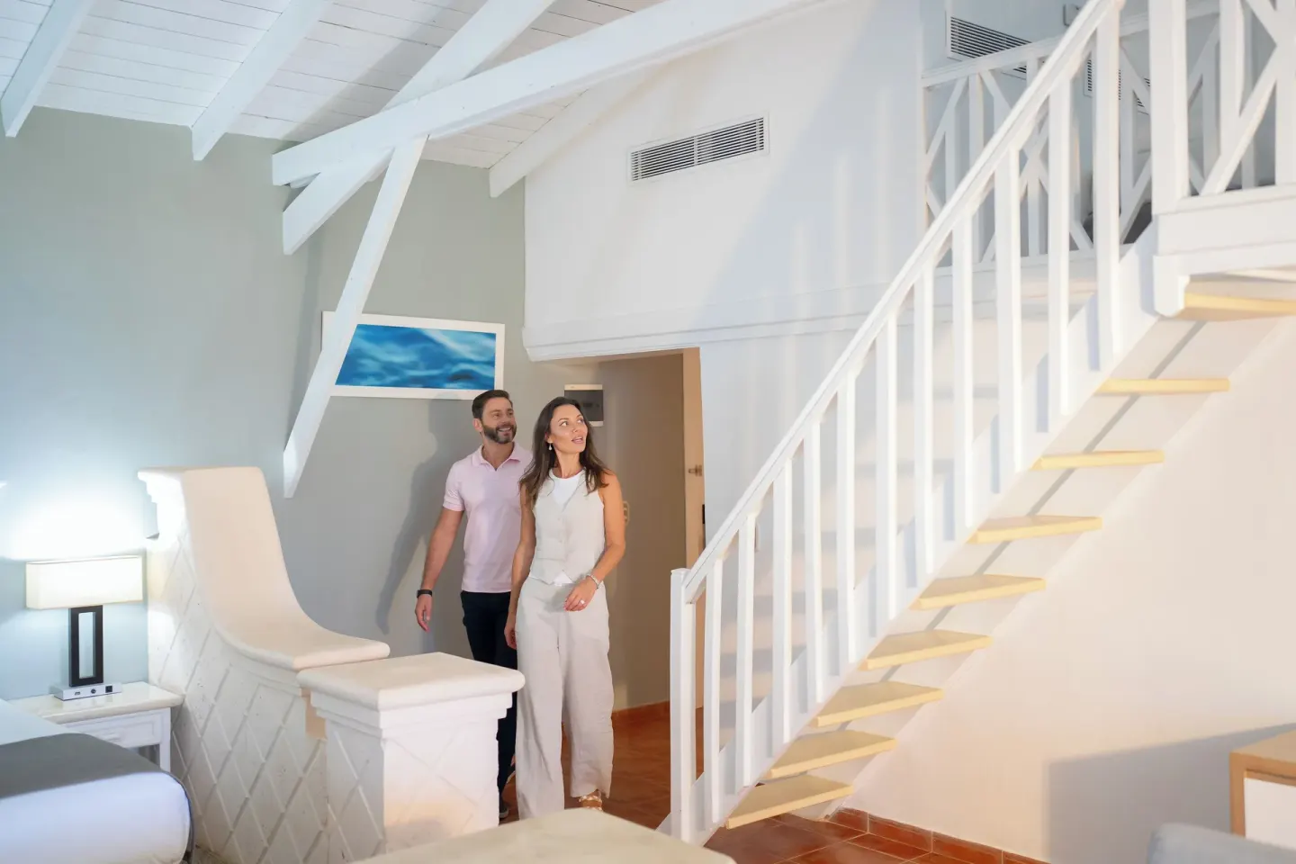 Club Bungalow Garden View room with king bed and white staircase at Wyndham Alltra Samana Resort.