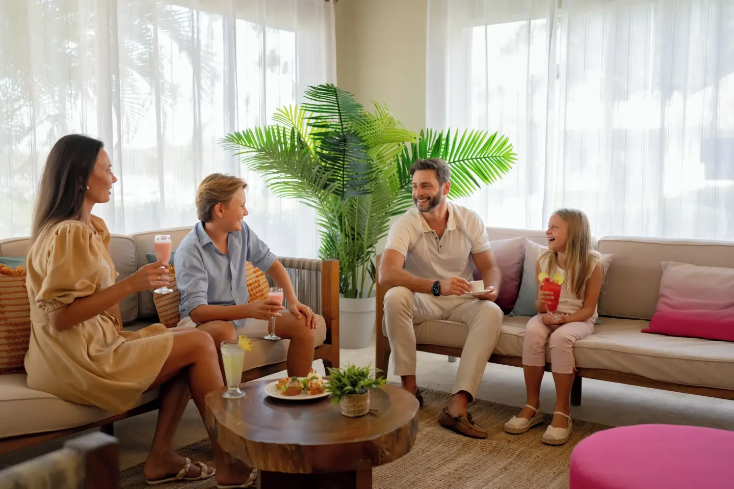Family seated with drinks in the Club lounge at Wyndham Alltra Samana Resort.