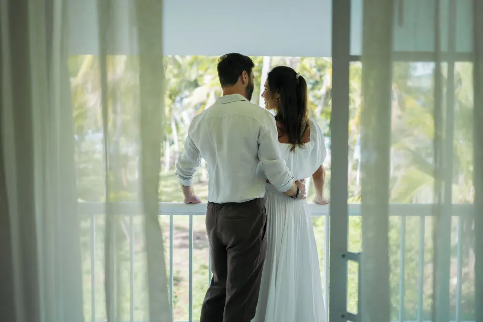Couple on a Club Room Ocean View balcony at Wyndham Alltra Samana Resort.