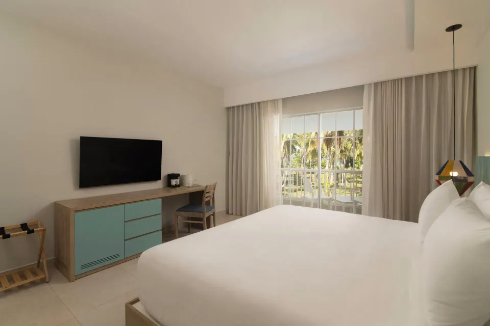 Club Room Ocean View king bed and balcony at Wyndham Alltra Samana Resort.