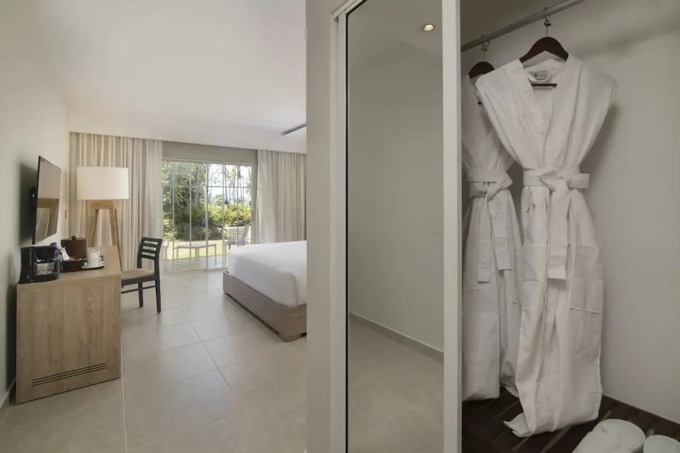 Standard Room Garden View closet robes and bedroom at Wyndham Alltra Samana Resort.