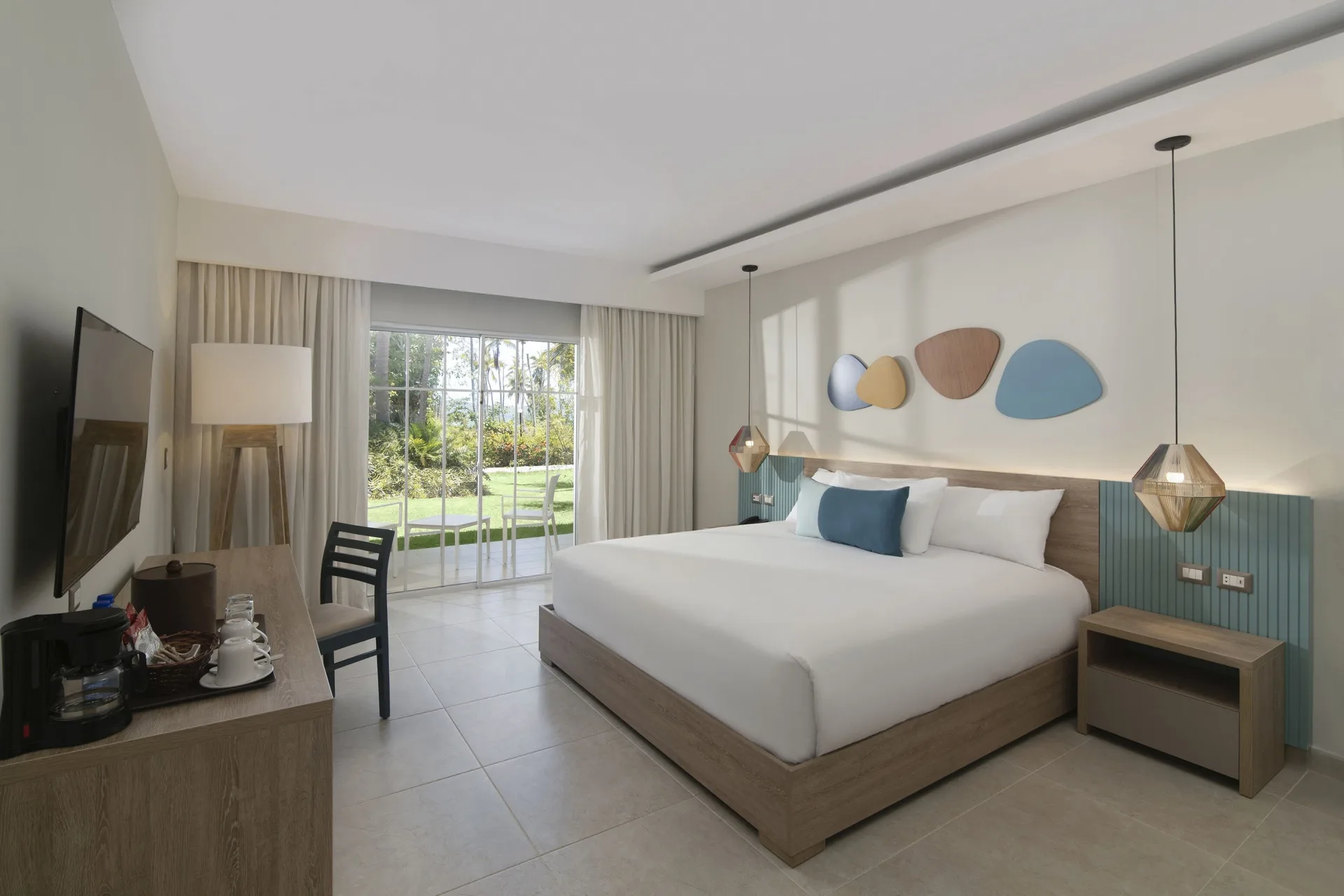 Standard Room Garden View king bed and patio doors at Wyndham Alltra Samana Resort.