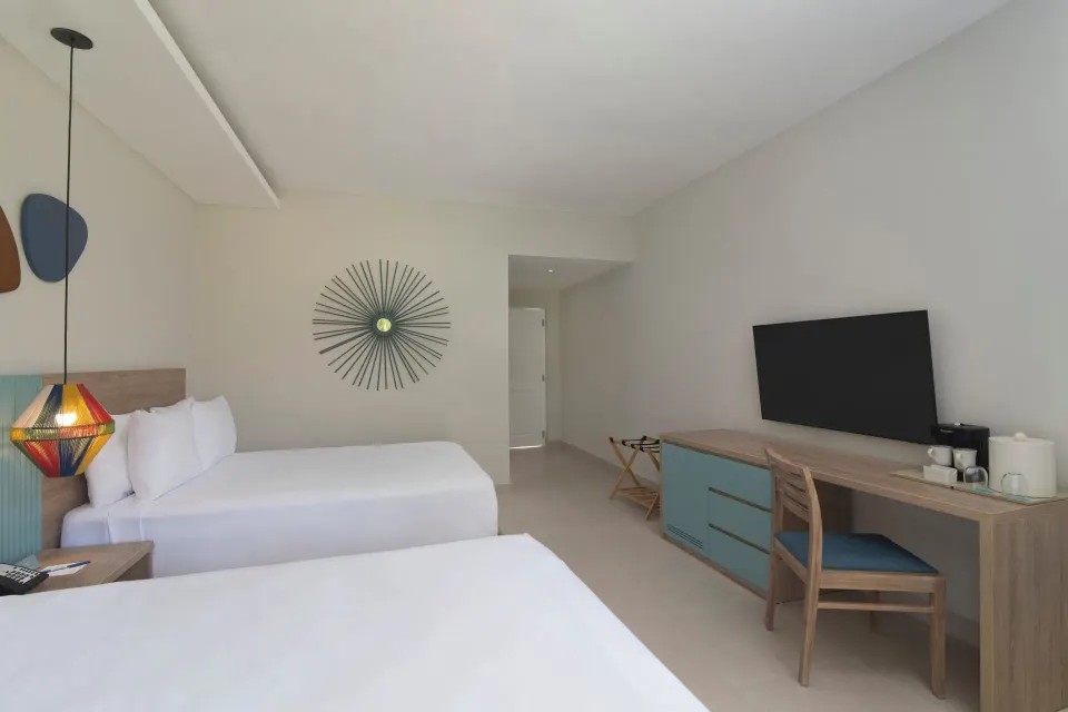 Standard Room Garden View double beds and TV desk at Wyndham Alltra Samana Resort.
