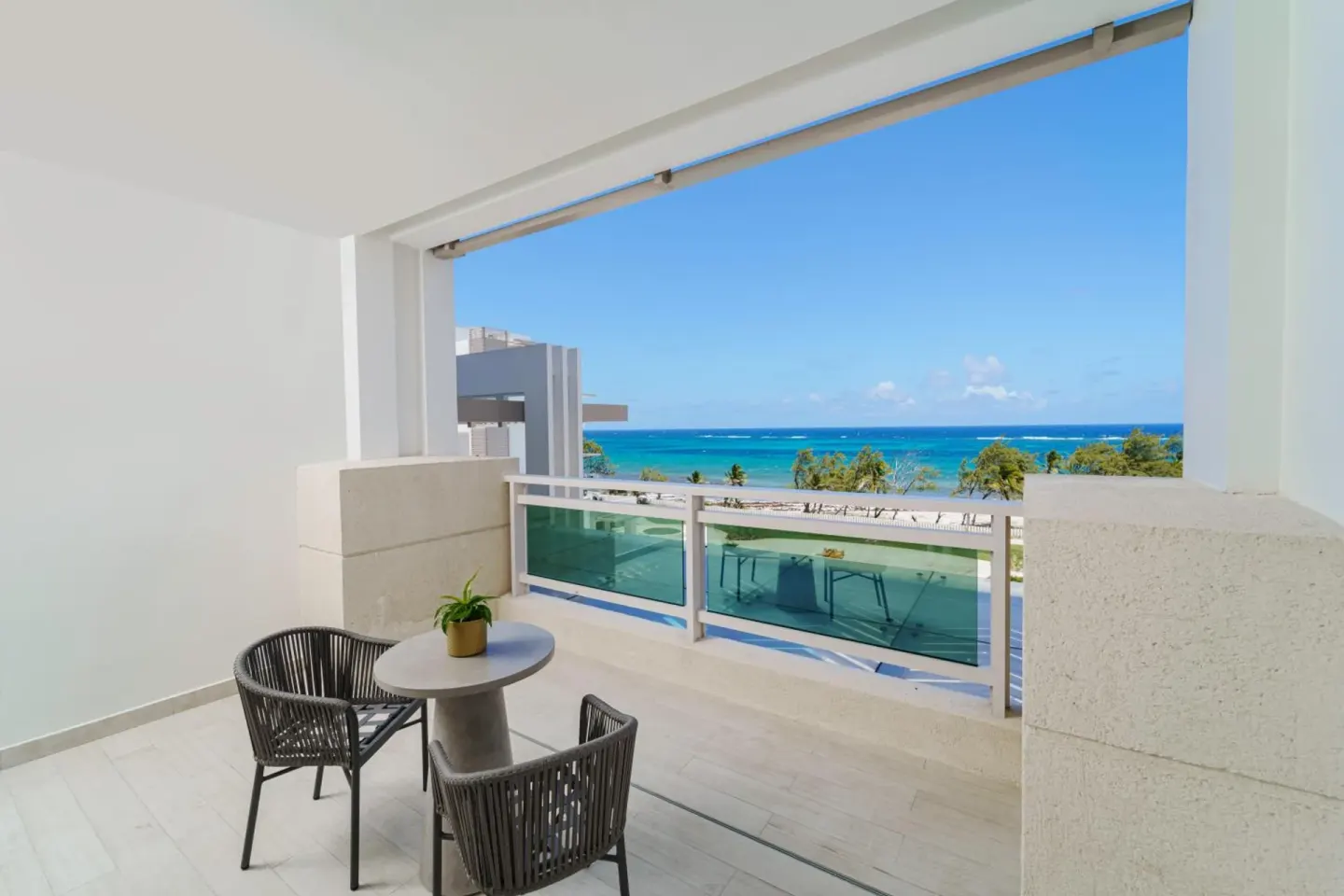 Covered balcony seating with ocean view at Wyndham Grand Barbados Sam Lords Castle.
