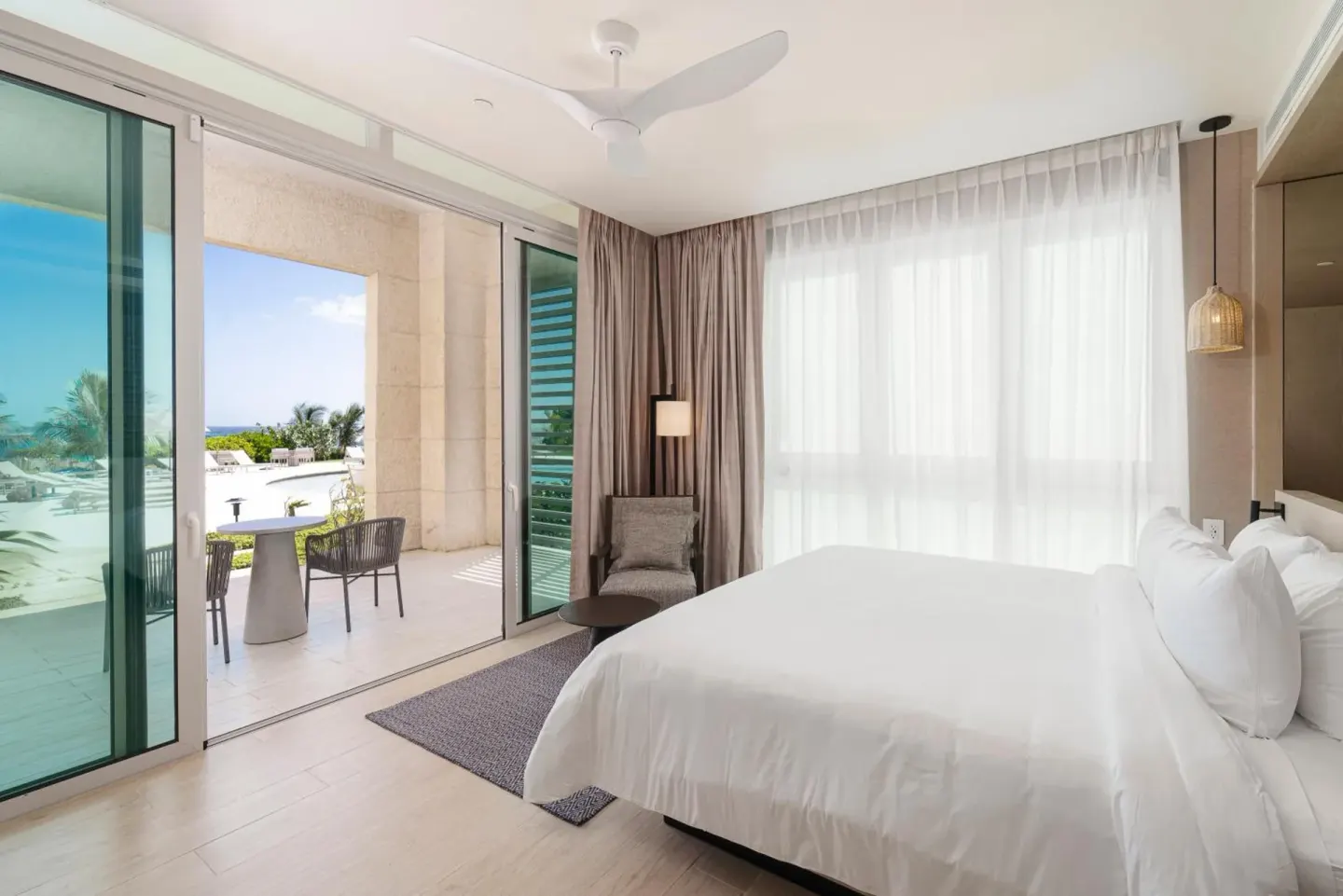 King bed guest room with terrace and ocean glimpse at Wyndham Grand Barbados Sam Lords Castle.