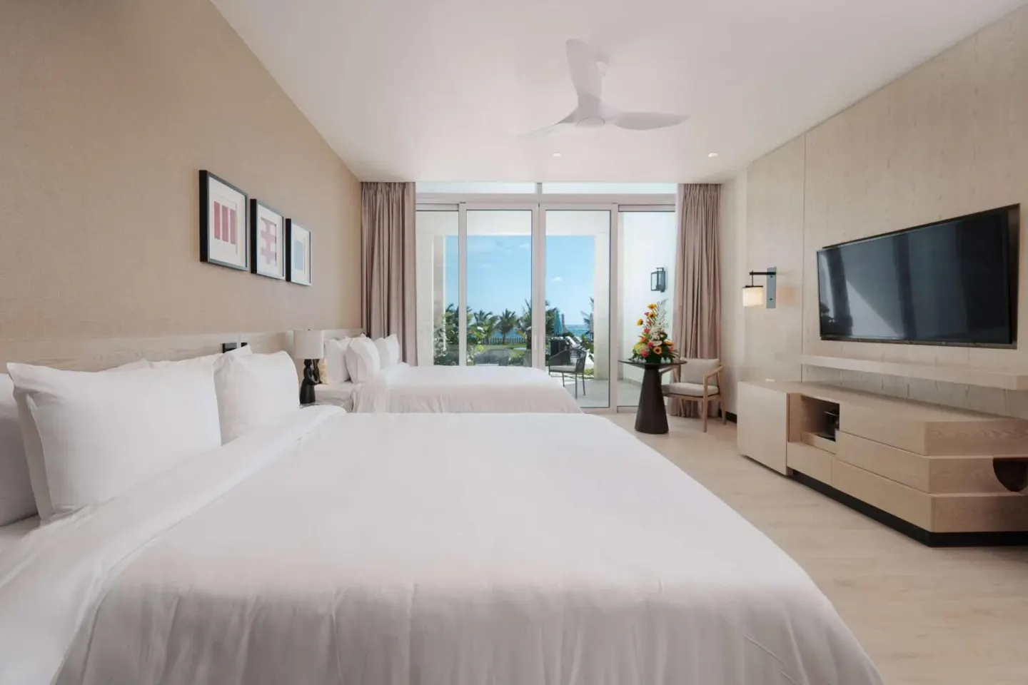 Guest room with two queen beds, TV, and balcony view at Wyndham Grand Barbados Sam Lords Castle.