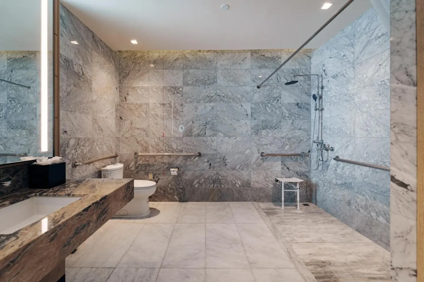 Wide marble accessible bathroom with open shower at Wyndham Grand Barbados Sam Lords Castle.