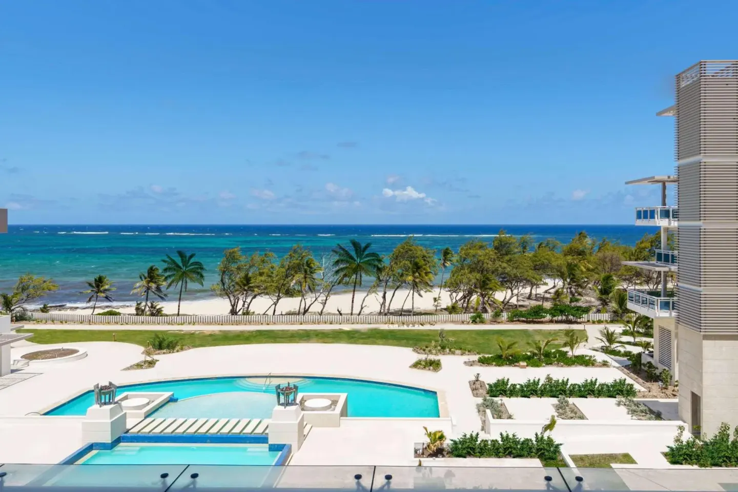 Resort pool, beach, palms, and ocean at Wyndham Grand Barbados Sam Lords Castle.