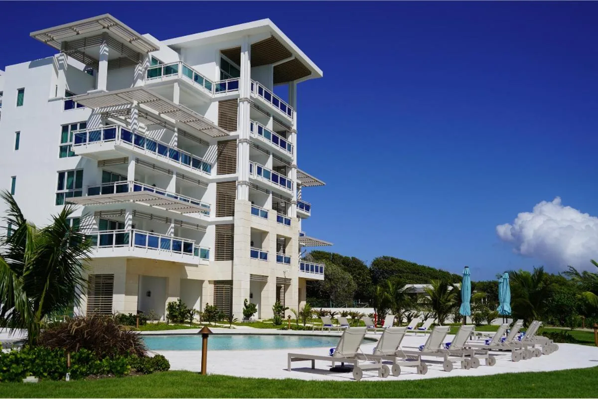 Resort building, pool deck, and lounge chairs at Wyndham Grand Barbados Sam Lords Castle.