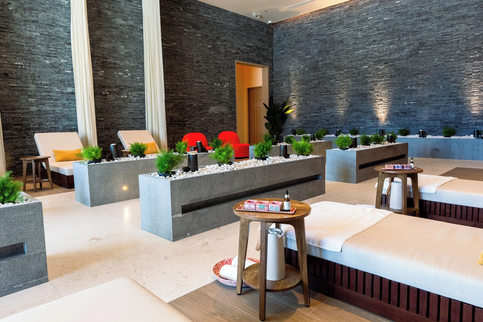 Spa relaxation lounge with loungers and planters at Wyndham Grand Barbados Sam Lords Castle.