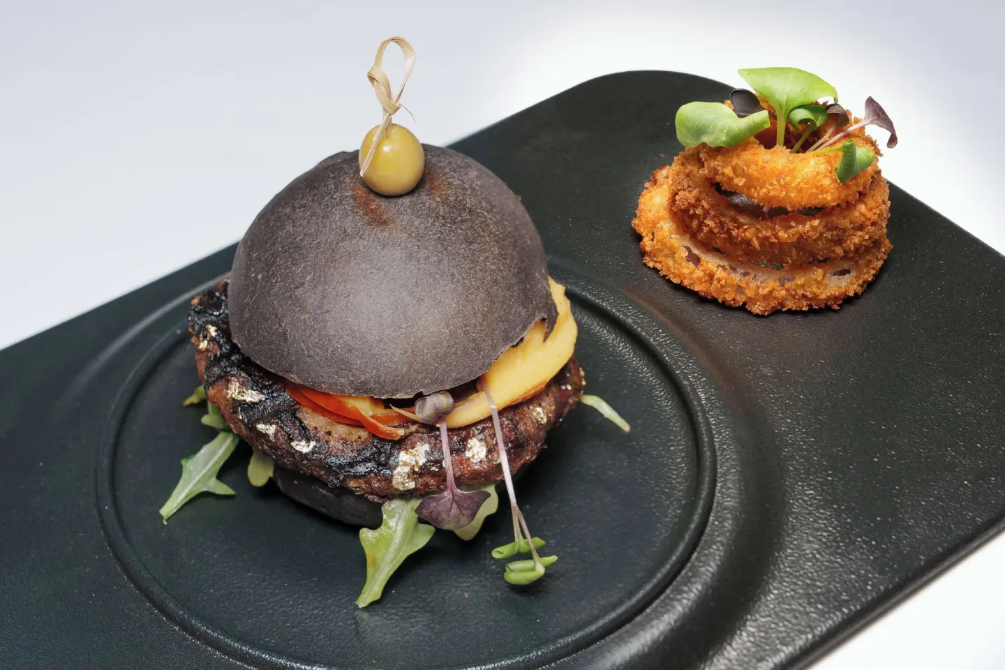 Plated burger with onion rings at Wyndham Grand Barbados Sam Lords Castle.