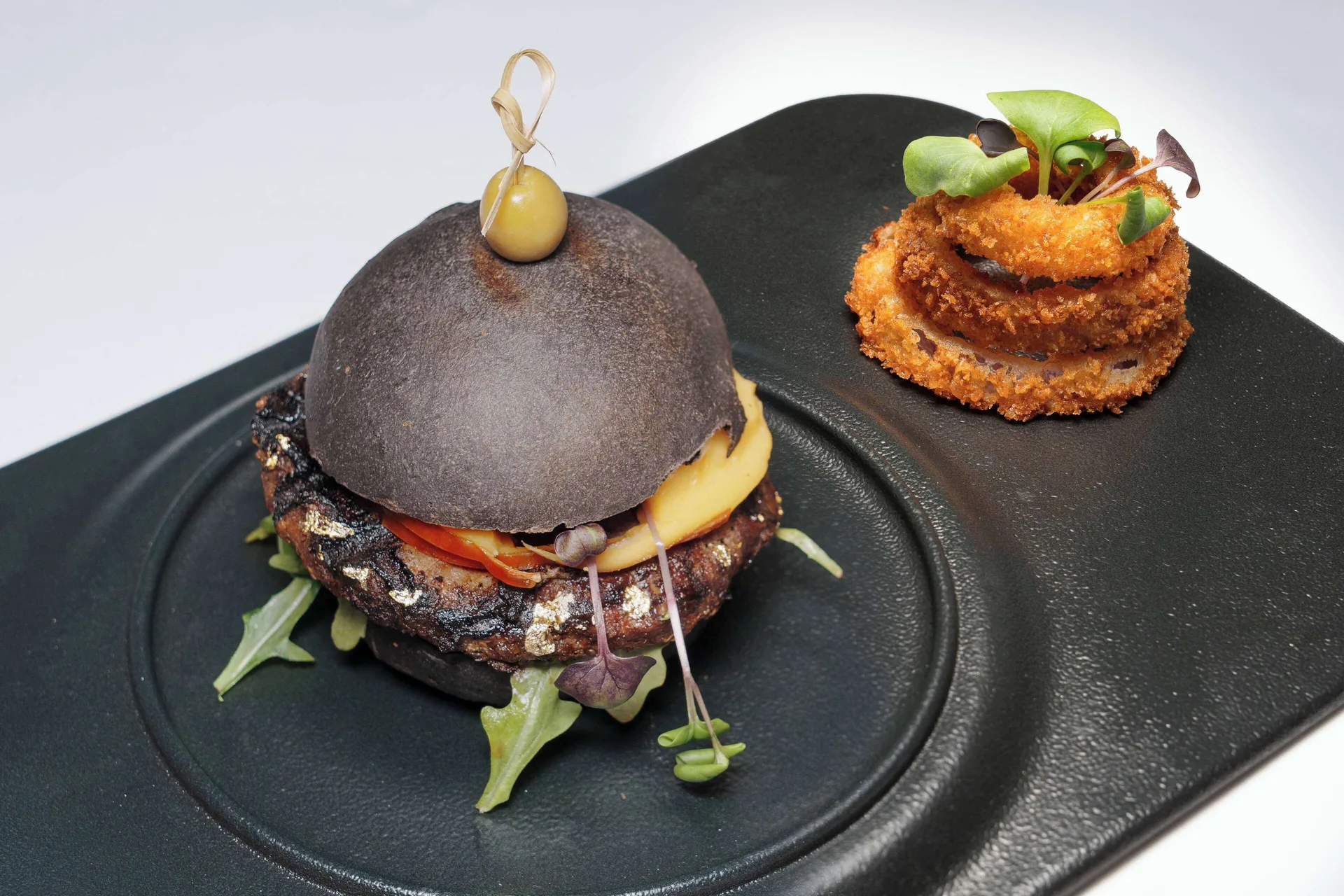 Plated burger with onion rings at Wyndham Grand Barbados Sam Lords Castle.