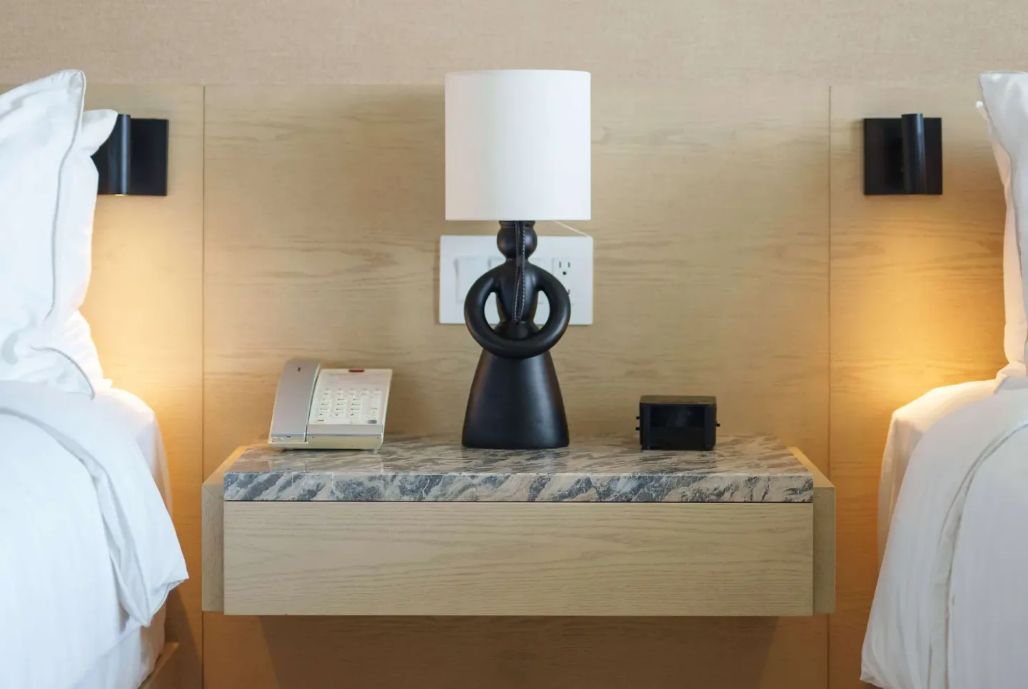 Bedside table between two beds in a Deluxe Room at Wyndham Grand Barbados Sam Lords Castle.