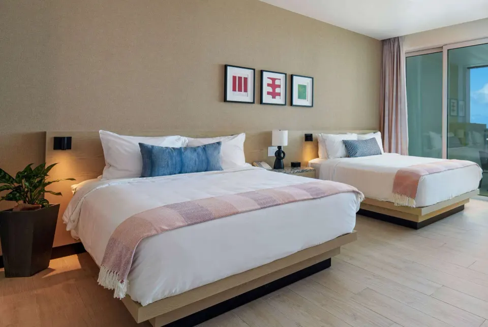Two queen beds in a Deluxe Room Resort View at Wyndham Grand Barbados Sam Lords Castle.