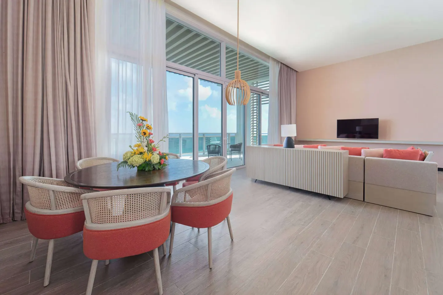 Ocean suite dining and lounge area with balcony doors at Wyndham Grand Barbados Sam Lords Castle.