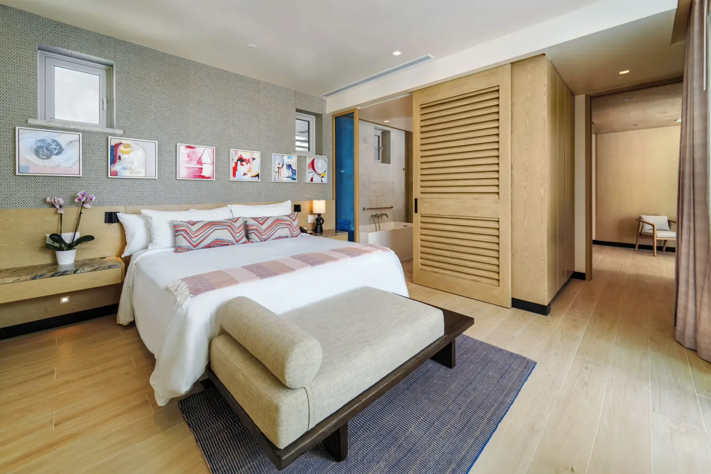 Zephyr Suite king bedroom with bench and open bath area at Wyndham Grand Barbados Sam Lords Castle.