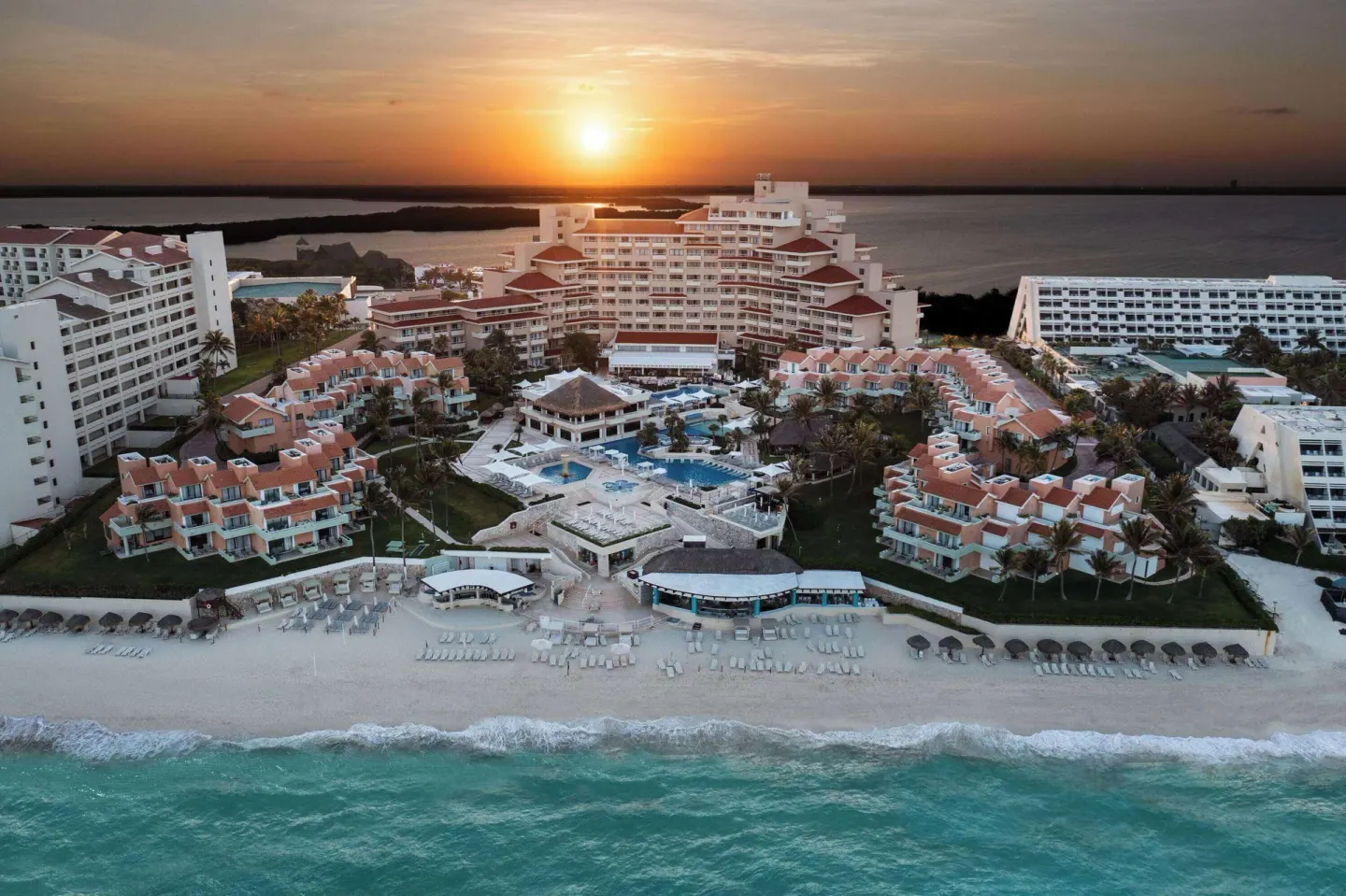 Aerial beachfront view of Wyndham Grand Cancun Resort & Villas at sunset.