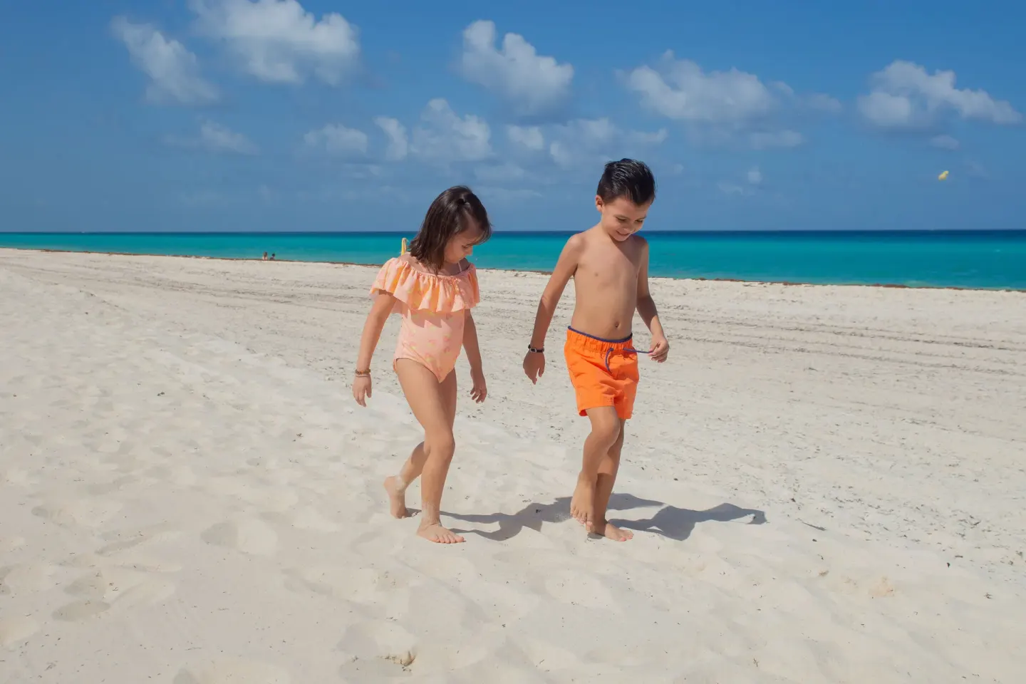 Children walking on the beach at Wyndham Grand Cancun Resort & Villas.