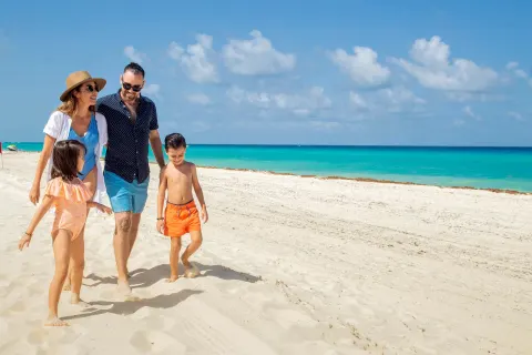 Family walking on the beach at Wyndham Grand Cancun Resort & Villas.