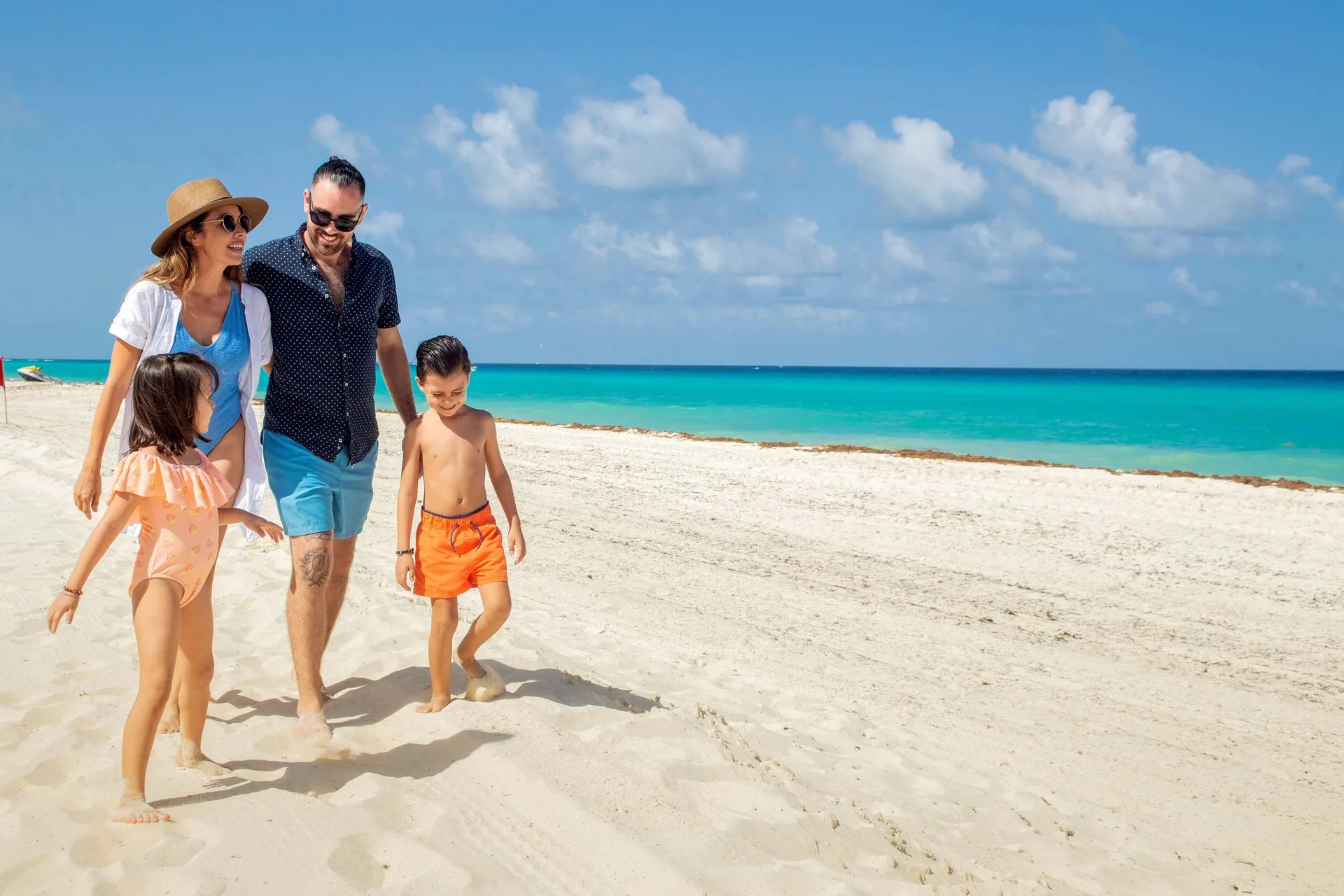 Family walking on the beach at Wyndham Grand Cancun Resort & Villas.